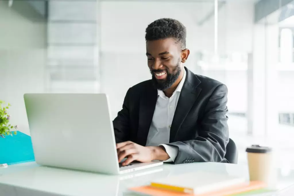 Foto de homem advogado sorridente ao utilizar beneficios de um software para advogados